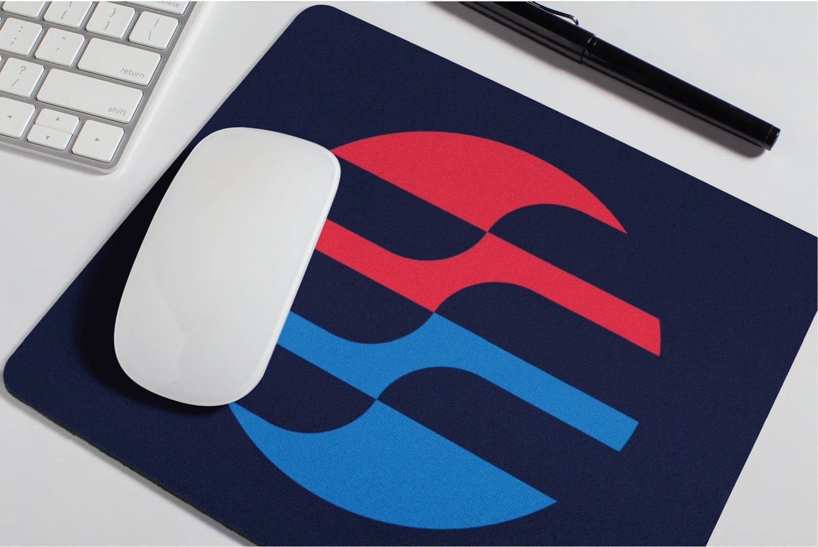 A navy mousepad printed with the airflow mark, on a desk beside a keyboard