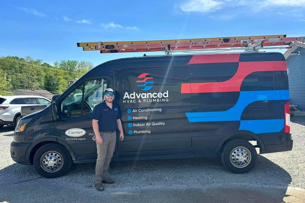 A wrapped Advanced HVAC & Plumbing service van with a technician standing beside it