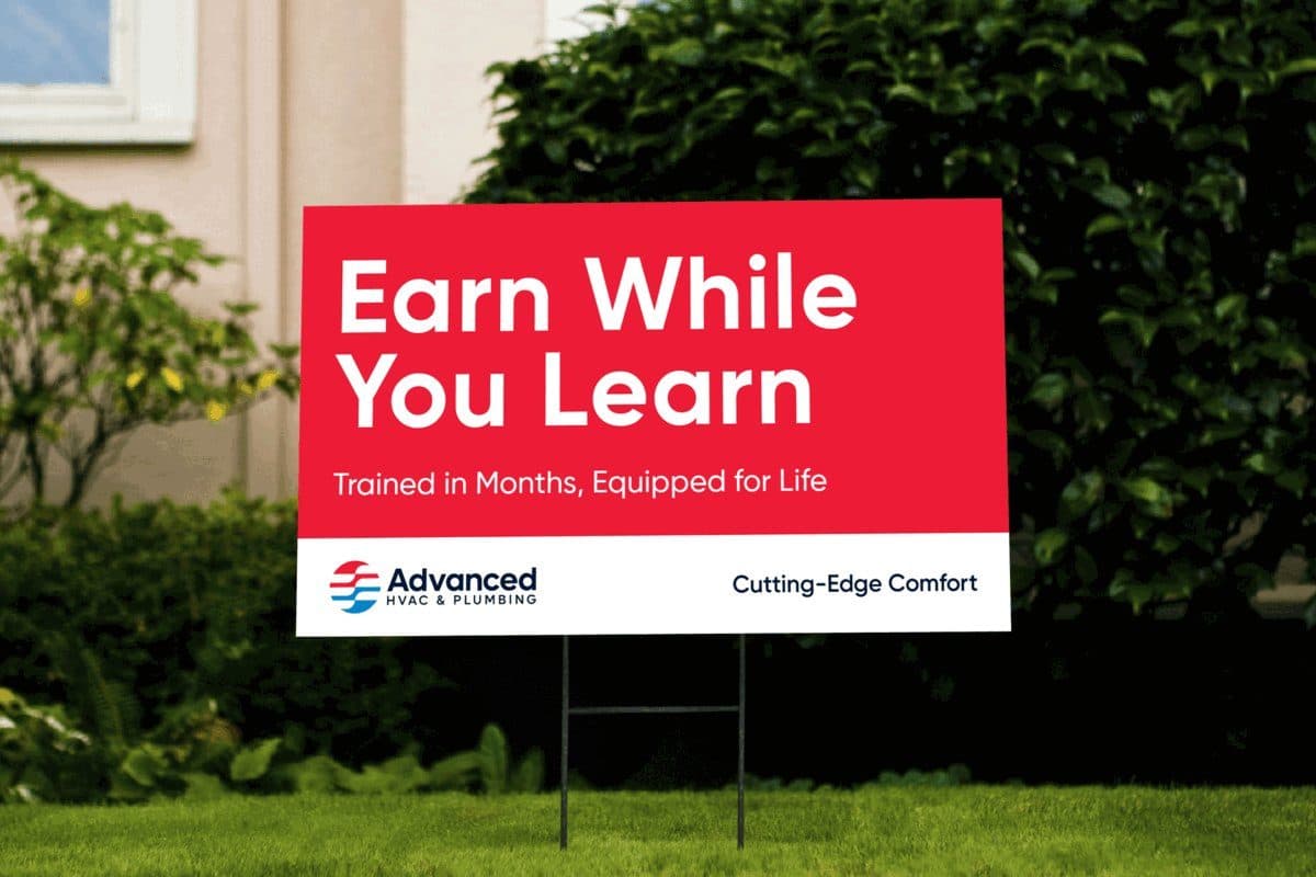 A red lawn sign reading “Earn While You Learn — trained in months, equipped for life”